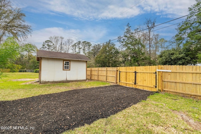 view of yard with an outdoor structure, fence, and a gate