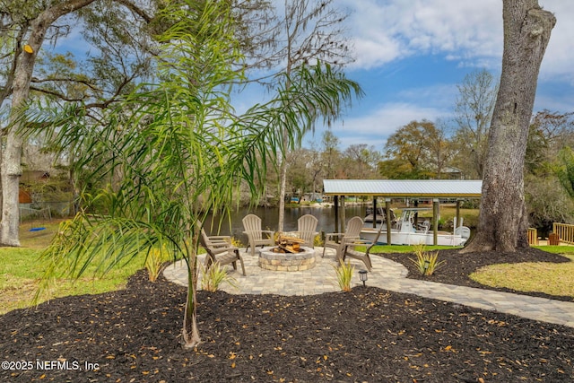 view of yard with an outdoor fire pit, a water view, and a patio