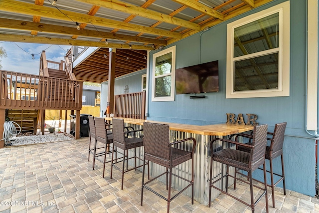 view of patio / terrace featuring outdoor dry bar and stairs