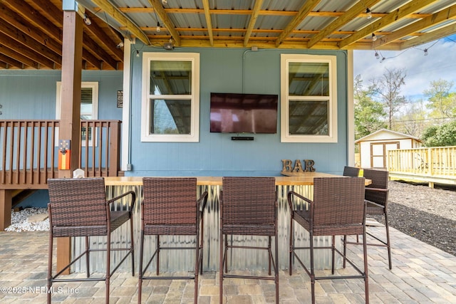 view of patio / terrace featuring outdoor dry bar, a storage unit, and an outdoor structure