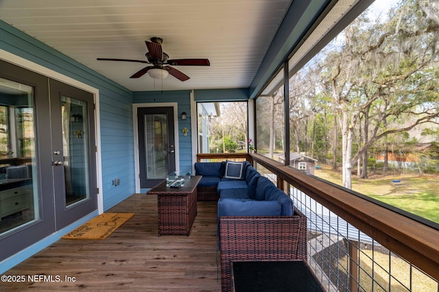 unfurnished sunroom featuring ceiling fan and french doors