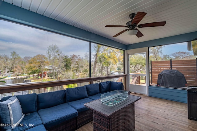 sunroom / solarium featuring a ceiling fan