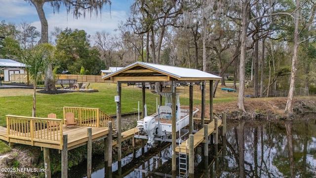 view of dock with a yard, boat lift, and fence