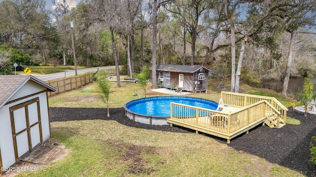 outdoor pool featuring an outbuilding, a yard, a storage shed, and a wooden deck