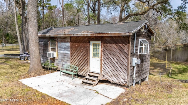 view of outdoor structure with entry steps, fence, cooling unit, and an outbuilding