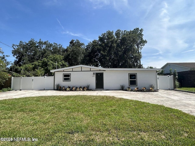 view of front of house with a gate, driveway, a front lawn, and fence