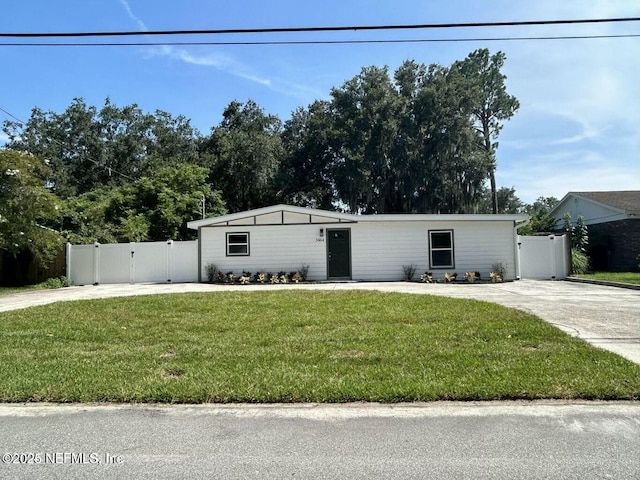 view of front of property with driveway, a gate, fence, and a front yard