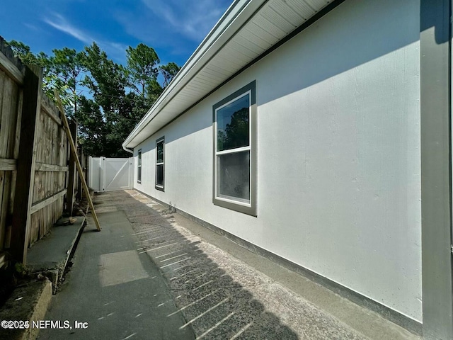 view of home's exterior featuring fence, a patio, and stucco siding