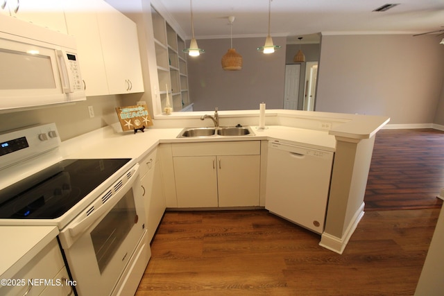 kitchen with white appliances, a peninsula, light countertops, crown molding, and a sink