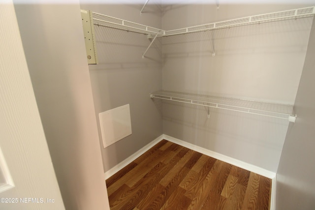 walk in closet with wood finished floors