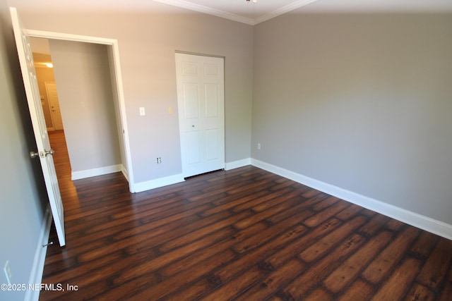 unfurnished bedroom with crown molding, dark wood finished floors, and baseboards