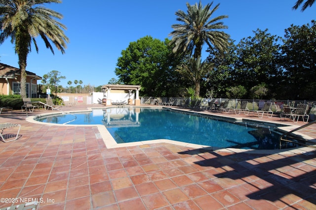 community pool featuring fence, a pergola, and a patio