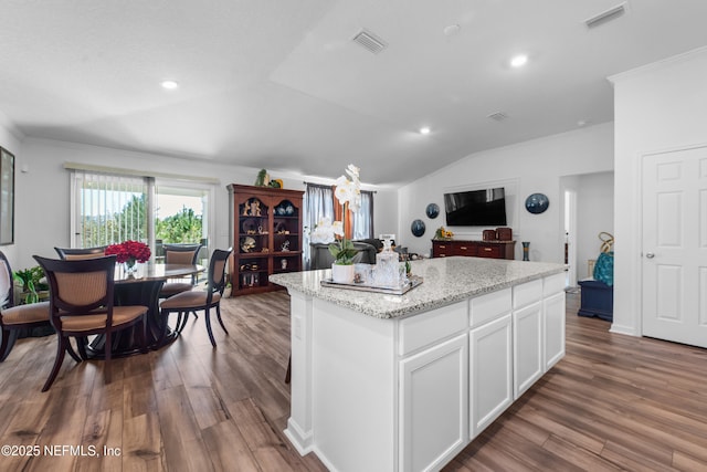 kitchen with visible vents, a kitchen island, and wood finished floors