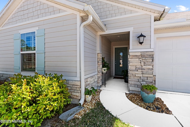 entrance to property with stone siding and a garage