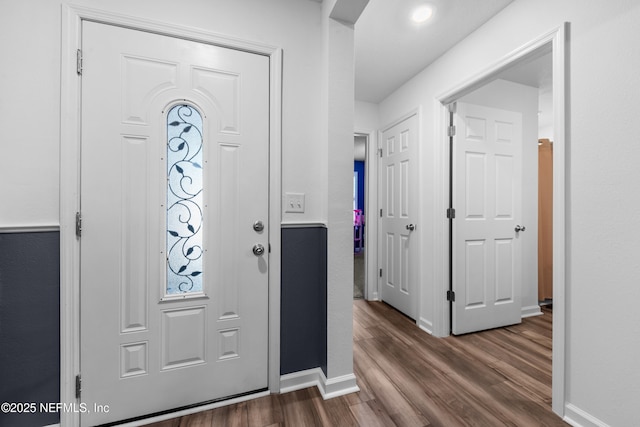 foyer entrance featuring dark wood-type flooring and baseboards