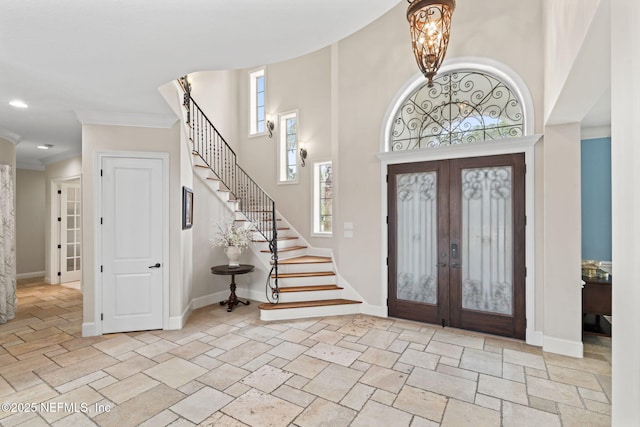 foyer featuring stairs, french doors, and baseboards