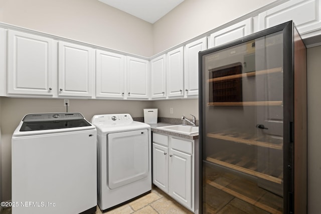 laundry room featuring a sink, wine cooler, washing machine and dryer, and cabinet space