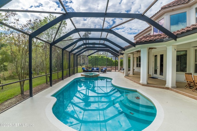 view of pool with a pool with connected hot tub, ceiling fan, a lanai, french doors, and a patio