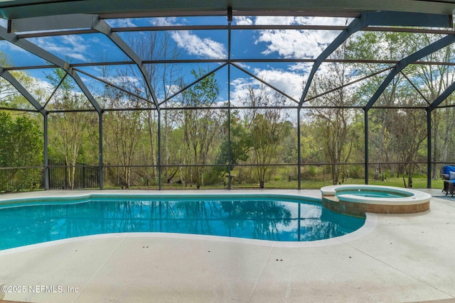 view of pool featuring glass enclosure, a patio, and a pool with connected hot tub
