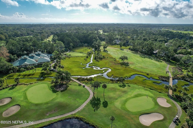 bird's eye view featuring a wooded view, golf course view, and a water view