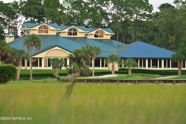 rear view of property featuring a yard and metal roof