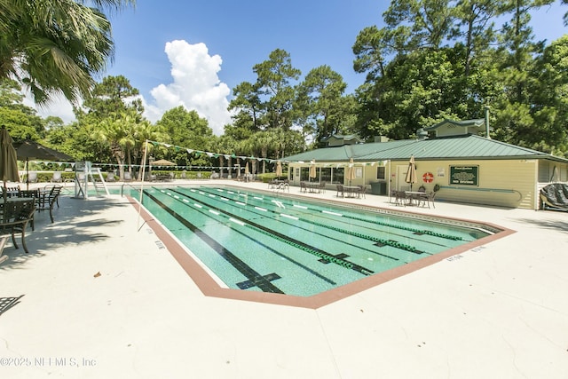 pool with a patio area and fence