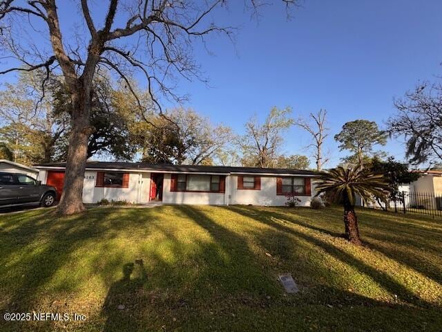 ranch-style house with fence and a front yard