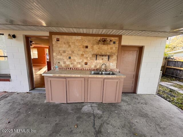 bar featuring unfinished concrete floors and a sink