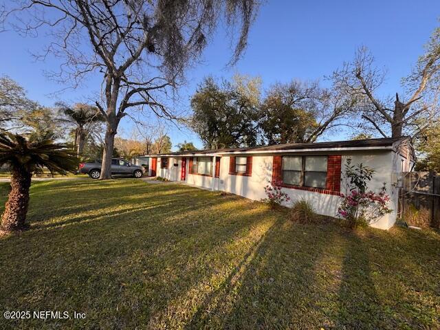 single story home featuring stucco siding and a front yard