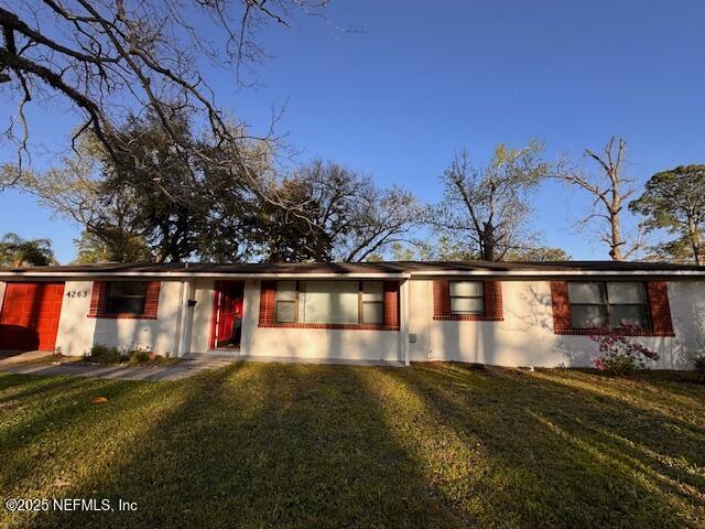 ranch-style home featuring an attached garage and a front lawn