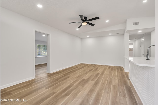 unfurnished living room with visible vents, plenty of natural light, and light wood finished floors