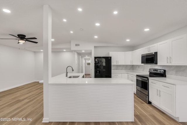 kitchen with light wood finished floors, visible vents, stainless steel appliances, light countertops, and a sink