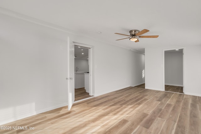 unfurnished bedroom with light wood-style floors, ceiling fan, and baseboards