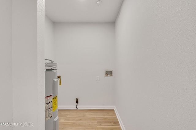 laundry area with hookup for a washing machine, laundry area, baseboards, water heater, and light wood-type flooring