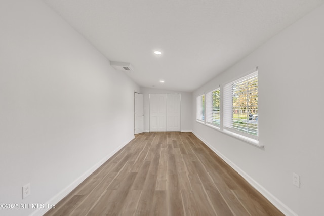 unfurnished room with recessed lighting, baseboards, and wood finished floors