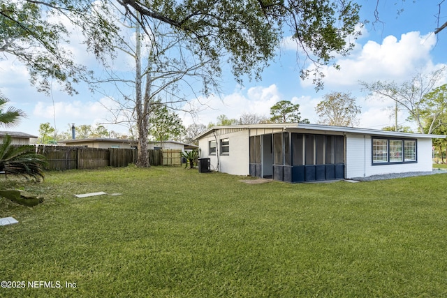 view of yard featuring a sunroom, fence, and central AC unit