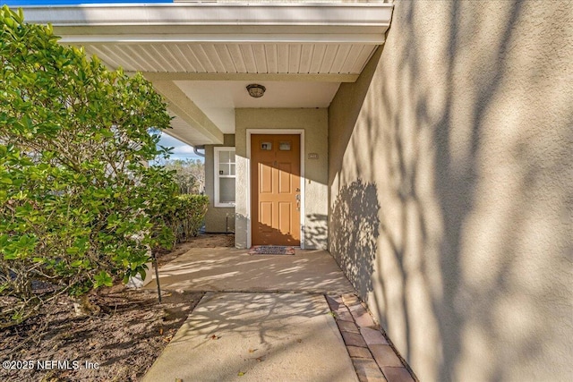 property entrance with stucco siding