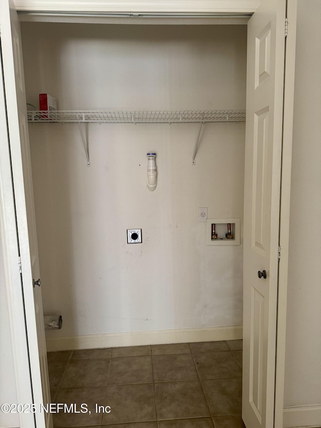 clothes washing area featuring hookup for a washing machine, hookup for an electric dryer, laundry area, dark tile patterned flooring, and baseboards