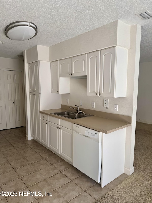 kitchen featuring a textured ceiling, a sink, visible vents, white cabinetry, and dishwasher