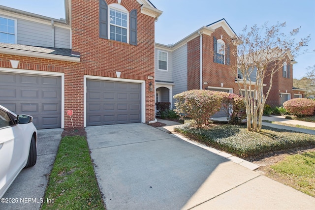 view of front of home with a garage, brick siding, and driveway