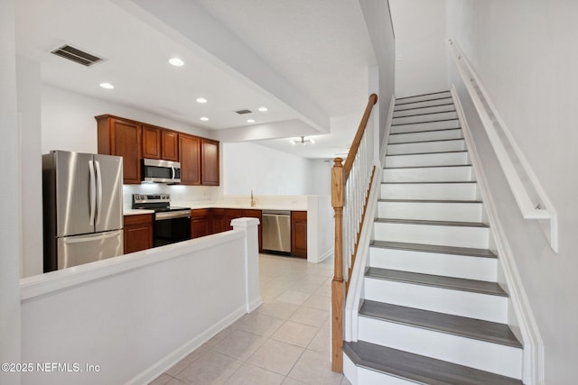 kitchen featuring light tile patterned floors, stainless steel appliances, recessed lighting, visible vents, and a peninsula