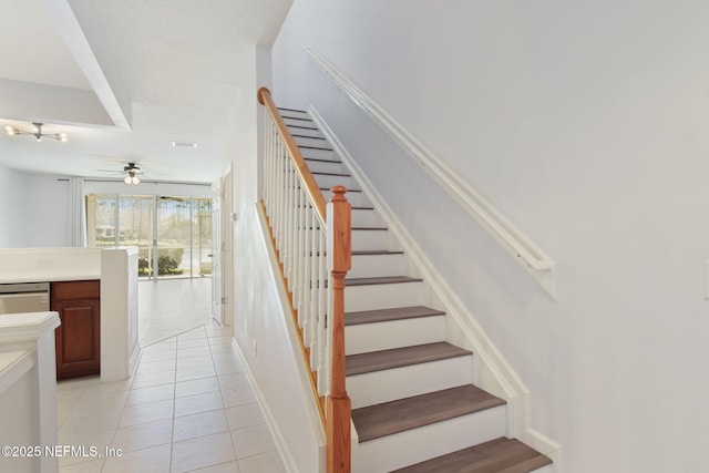 stairway with a ceiling fan and tile patterned flooring