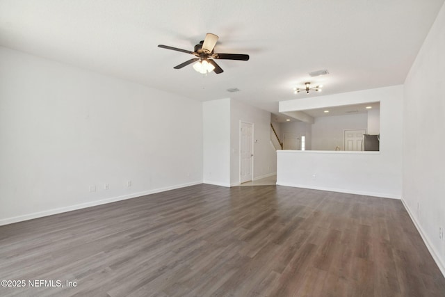 unfurnished living room featuring stairway, baseboards, visible vents, and dark wood-type flooring