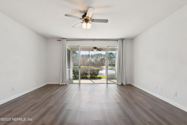 empty room with a ceiling fan, baseboards, and dark wood-type flooring