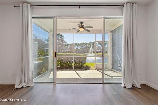 entryway featuring a ceiling fan, baseboards, and wood finished floors