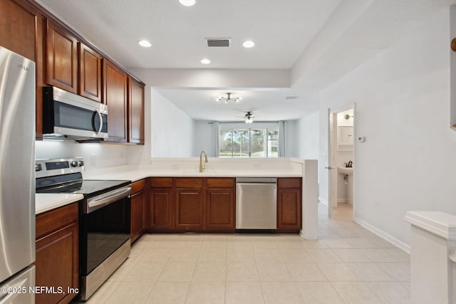 kitchen featuring stainless steel appliances, light countertops, visible vents, and a sink