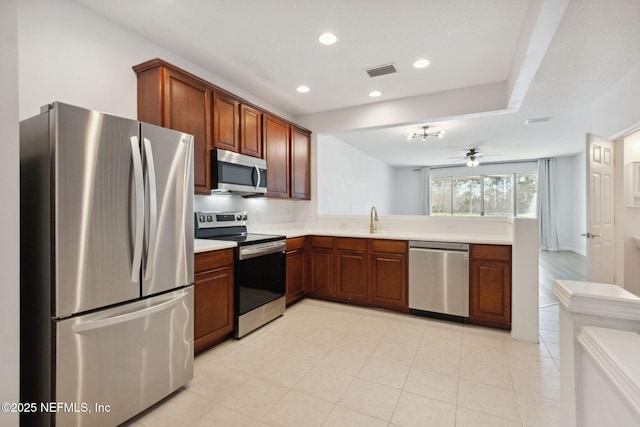 kitchen with visible vents, a peninsula, stainless steel appliances, light countertops, and recessed lighting