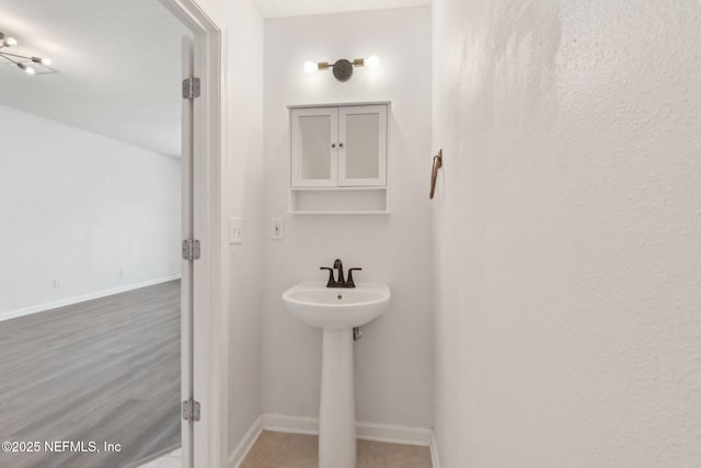 bathroom featuring a sink, baseboards, and wood finished floors