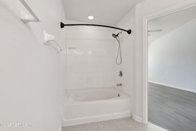 bathroom featuring tile patterned flooring, bathtub / shower combination, and baseboards