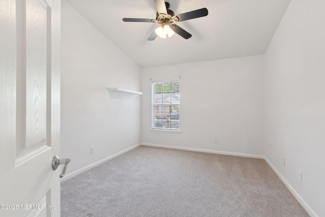 carpeted spare room with vaulted ceiling, baseboards, and ceiling fan